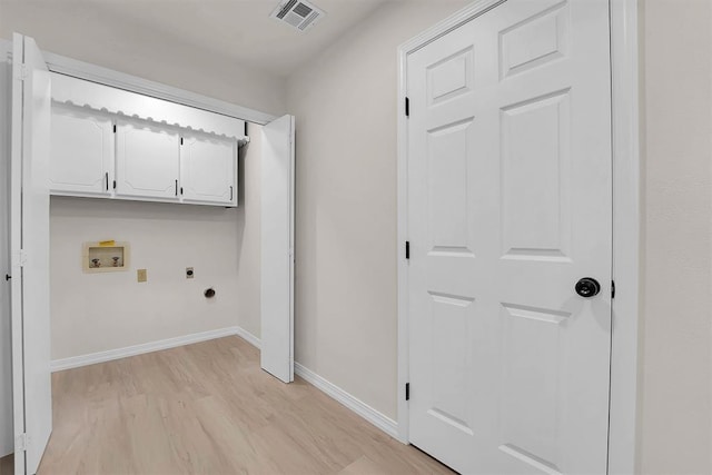 1712 N 4th St, Sayre, OK 73662 - washroom with electric dryer hookup, cabinet space, light wood-style flooring, and washer hookup