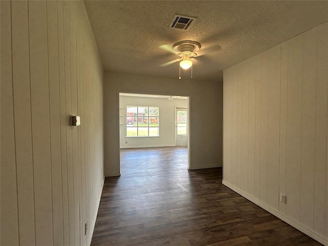 1708 W Modelle Ave, Clinton, OK 73601 - unfurnished room with dark wood-type flooring, ceiling fan, wood walls, and a textured ceiling
