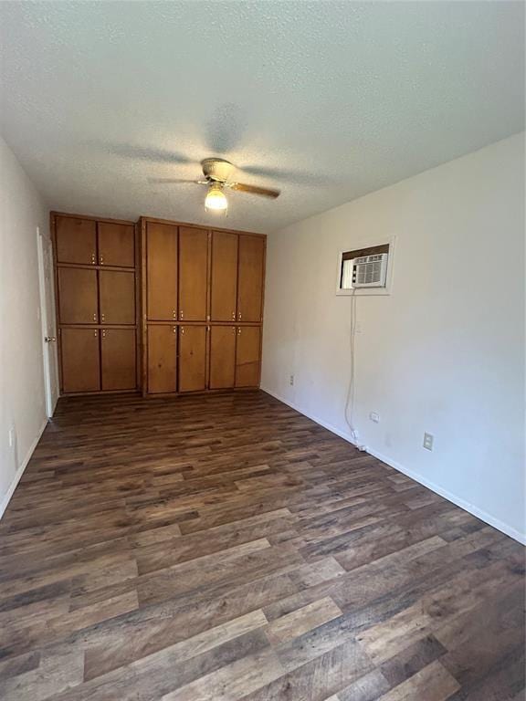 1708 W Modelle Ave, Clinton, OK 73601 - unfurnished bedroom featuring dark wood-type flooring, a wall mounted air conditioner, a textured ceiling, and ceiling fan