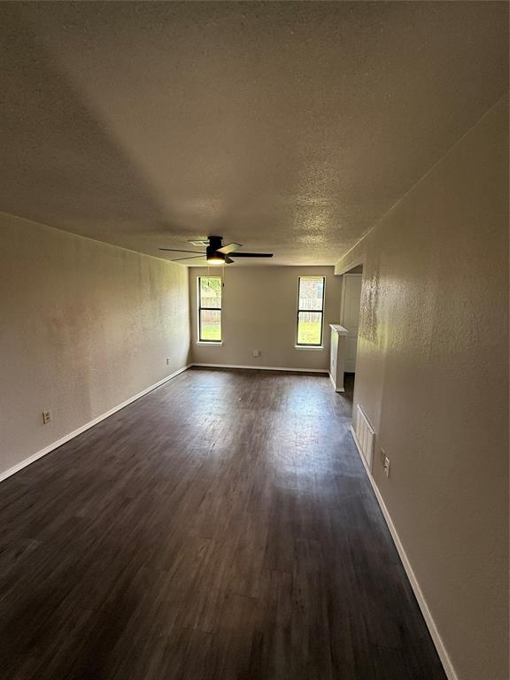 1213 Dreessen Dr, Moore, OK 73160 - spare room featuring ceiling fan, dark wood-style flooring, and a textured ceiling