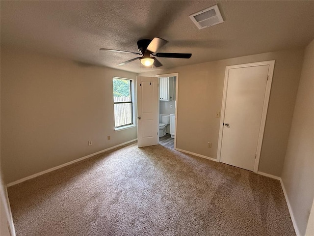 1213 Dreessen Dr, Moore, OK 73160 - unfurnished bedroom with carpet, connected bathroom, a textured ceiling, and a ceiling fan