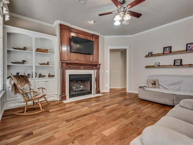 1810 Sandpiper Dr, Blanchard, OK 73010 - living room featuring a ceiling fan, ornamental molding, light wood-style floors, and a fireplace