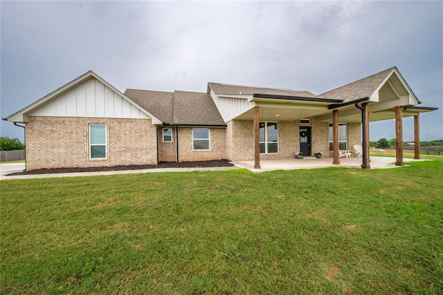 2326 County Road 1335, Blanchard, OK 73010 - view of front of home featuring a front yard, a patio, roof with shingles, brick siding, and board and batten siding