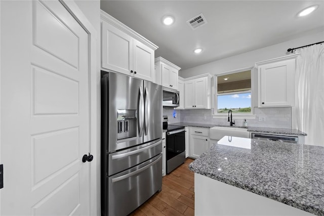 2326 County Road 1335, Blanchard, OK 73010 - kitchen with stainless steel appliances, white cabinetry, dark wood-style floors, backsplash, and light stone countertops