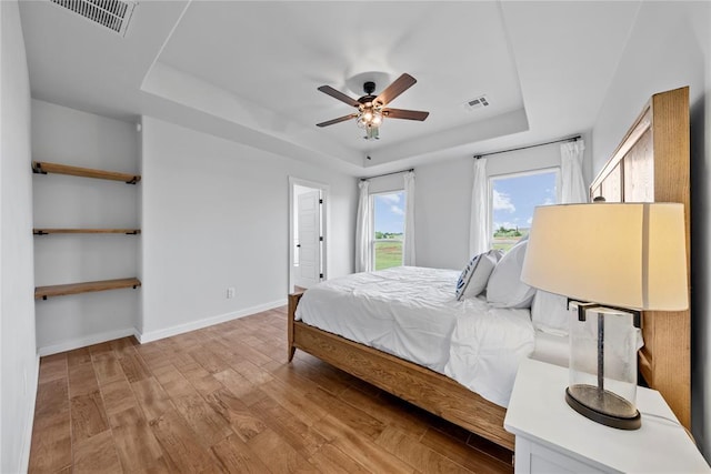 2326 County Road 1335, Blanchard, OK 73010 - bedroom featuring a raised ceiling, light wood-type flooring, and ceiling fan