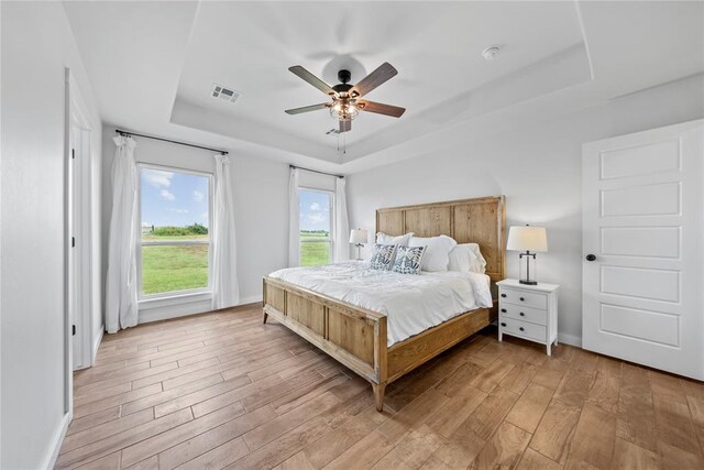 2326 County Road 1335, Blanchard, OK 73010 - bedroom with a raised ceiling, light wood-style floors, and ceiling fan