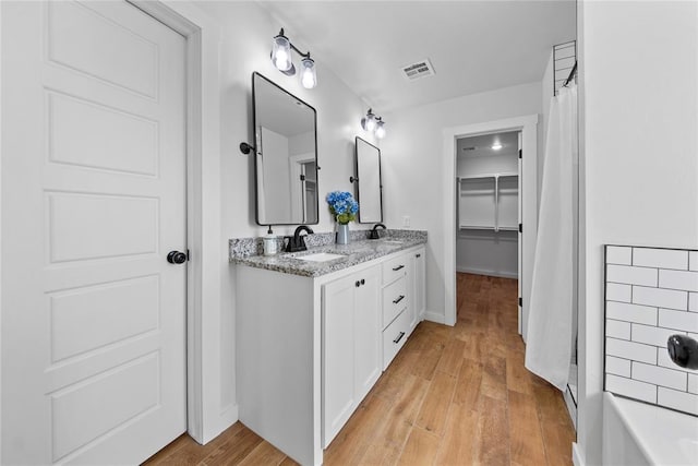 2326 County Road 1335, Blanchard, OK 73010 - full bath with double vanity, wood finished floors, a tub to relax in, and curtained shower