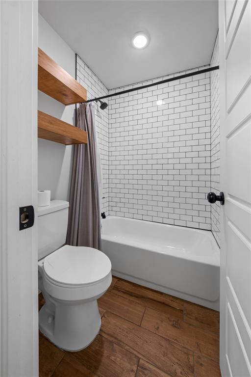 2326 County Road 1335, Blanchard, OK 73010 - bathroom featuring shower / bath combination with curtain and wood finished floors