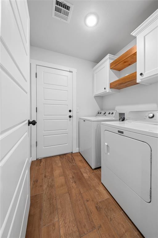 2326 County Road 1335, Blanchard, OK 73010 - laundry area featuring cabinet space, washing machine and dryer, and light wood-type flooring