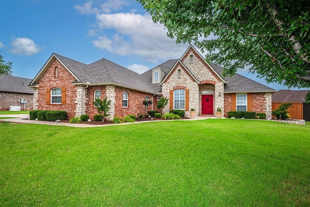 1865 Buckskin Ct, Blanchard, OK 73010 - french provincial home featuring a front lawn, stone siding, roof with shingles, and brick siding