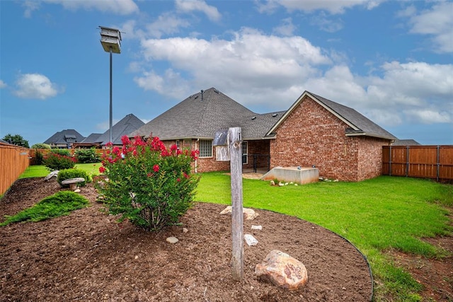 1865 Buckskin Ct, Blanchard, OK 73010 - rear view of house featuring a fenced backyard, brick siding, and a shingled roof