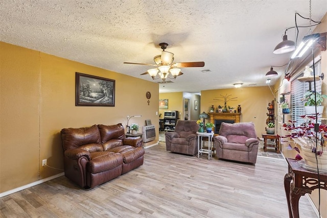 349760 E 970th Rd, Sparks, OK 74869 - living area featuring light wood-style flooring, ceiling fan, a fireplace, and a textured ceiling