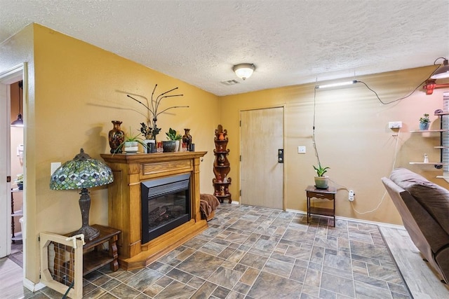 349760 E 970th Rd, Sparks, OK 74869 - entryway featuring a textured ceiling, a glass covered fireplace, and stone finish floors