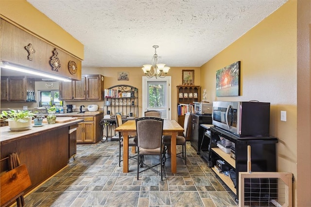 349760 E 970th Rd, Sparks, OK 74869 - dining area with a chandelier, stone finish flooring, and a textured ceiling