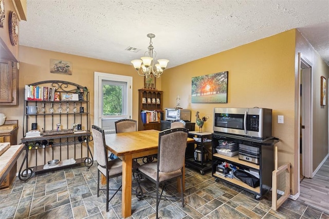 349760 E 970th Rd, Sparks, OK 74869 - dining space with a chandelier, a textured ceiling, and stone finish floors