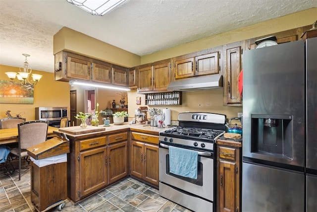 349760 E 970th Rd, Sparks, OK 74869 - kitchen with appliances with stainless steel finishes, under cabinet range hood, a textured ceiling, a peninsula, and a chandelier