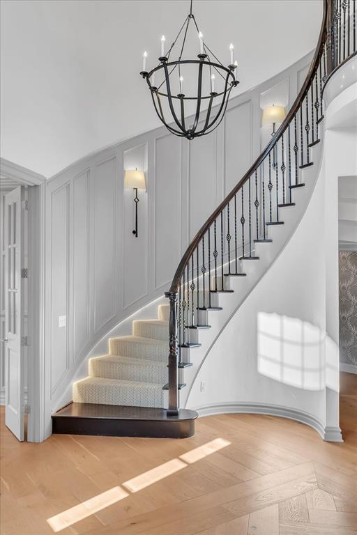 108 E Stroh Ave, Okarche, OK 73762 - staircase featuring a decorative wall, a chandelier, and wood finished floors