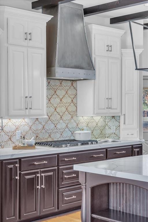 108 E Stroh Ave, Okarche, OK 73762 - kitchen with white cabinets, dark brown cabinets, backsplash, and custom range hood