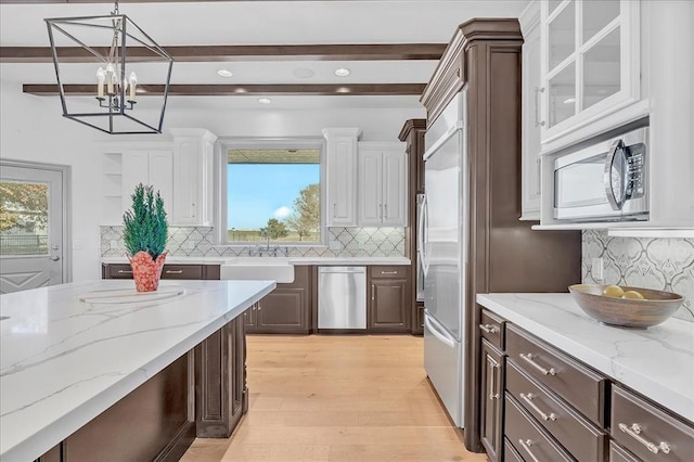 108 E Stroh Ave, Okarche, OK 73762 - kitchen with dark brown cabinets, white cabinetry, stainless steel appliances, light wood-type flooring, and decorative backsplash