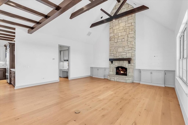 108 E Stroh Ave, Okarche, OK 73762 - unfurnished living room with beam ceiling, light wood-style floors, high vaulted ceiling, and a fireplace
