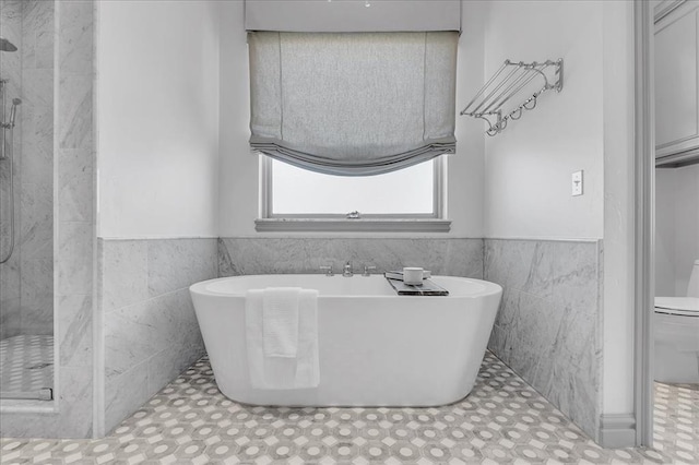 108 E Stroh Ave, Okarche, OK 73762 - bathroom with tile walls, wainscoting, a tile shower, and a freestanding bath