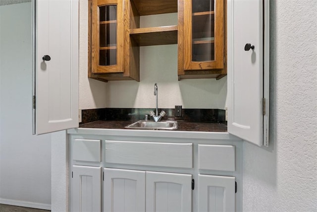 12073 N3540 Rd, Seminole, OK 74868 - kitchen featuring dark countertops, glass insert cabinets, a textured wall, and open shelves