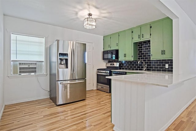 312 Jon St, Guthrie, OK 73044 - kitchen featuring stainless steel appliances, green cabinetry, light wood-type flooring, cooling unit, and tasteful backsplash