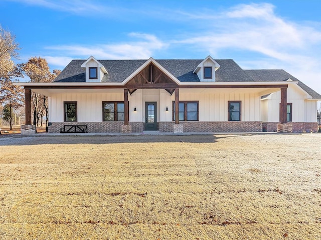 1092 S Mustang Rd, Blanchard, OK 73010 - modern farmhouse style home with brick siding, a porch, roof with shingles, and board and batten siding