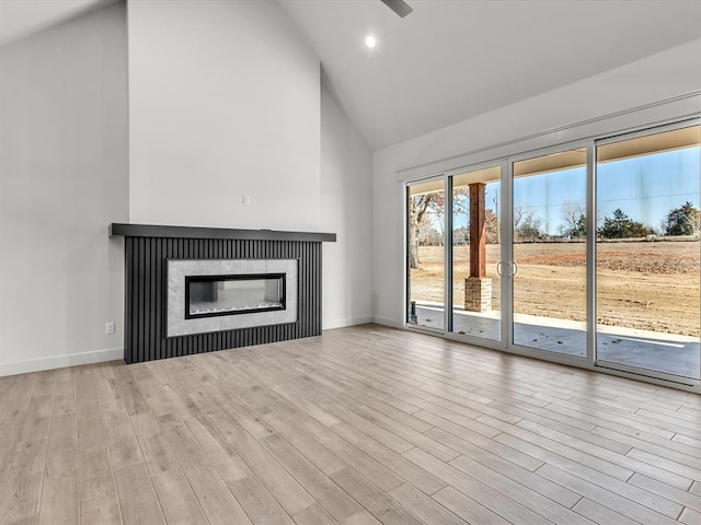 1092 S Mustang Rd, Blanchard, OK 73010 - unfurnished living room with high vaulted ceiling, wood finished floors, a glass covered fireplace, and recessed lighting