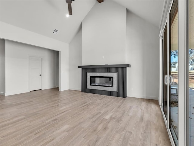 1092 S Mustang Rd, Blanchard, OK 73010 - unfurnished living room featuring high vaulted ceiling, light wood-type flooring, a glass covered fireplace, a ceiling fan, and beam ceiling