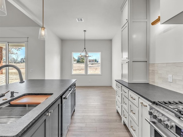 1092 S Mustang Rd, Blanchard, OK 73010 - kitchen with stainless steel appliances, healthy amount of natural light, dark countertops, and light wood-style floors