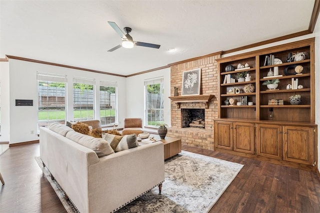 2717 Asheforde Oaks Blvd, Edmond, OK 73034 - living room with crown molding, dark wood-type flooring, ceiling fan, and a brick fireplace