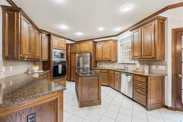 2717 Asheforde Oaks Blvd, Edmond, OK 73034 - kitchen featuring stainless steel appliances, tasteful backsplash, ornamental molding, brown cabinetry, and dark stone countertops