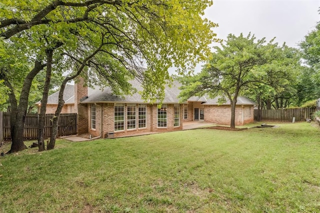 2717 Asheforde Oaks Blvd, Edmond, OK 73034 - back of property featuring brick siding, a chimney, a fenced backyard, and a patio area
