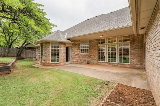 2717 Asheforde Oaks Blvd, Edmond, OK 73034 - rear view of property featuring a shingled roof, brick siding, and a patio area