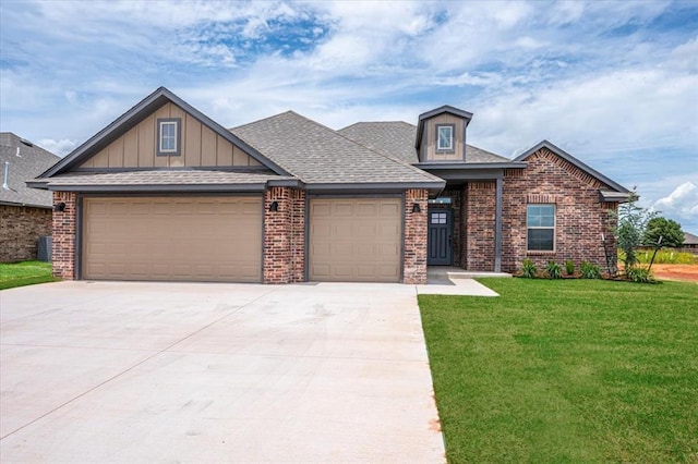 2013 W Crossbow Way, Mustang, OK 73064 - view of front of home featuring a garage, driveway, brick siding, a front lawn, and board and batten siding