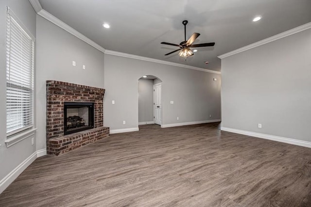 2013 W Crossbow Way, Mustang, OK 73064 - unfurnished living room with a ceiling fan, arched walkways, ornamental molding, a brick fireplace, and wood finished floors