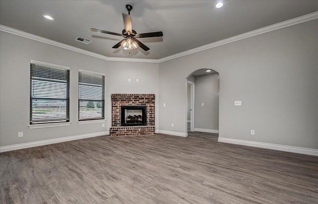 2013 W Crossbow Way, Mustang, OK 73064 - unfurnished living room with a ceiling fan, wood finished floors, arched walkways, crown molding, and a fireplace