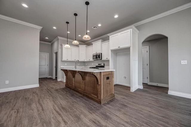 2013 W Crossbow Way, Mustang, OK 73064 - kitchen featuring stainless steel appliances, dark wood finished floors, crown molding, arched walkways, and white cabinetry