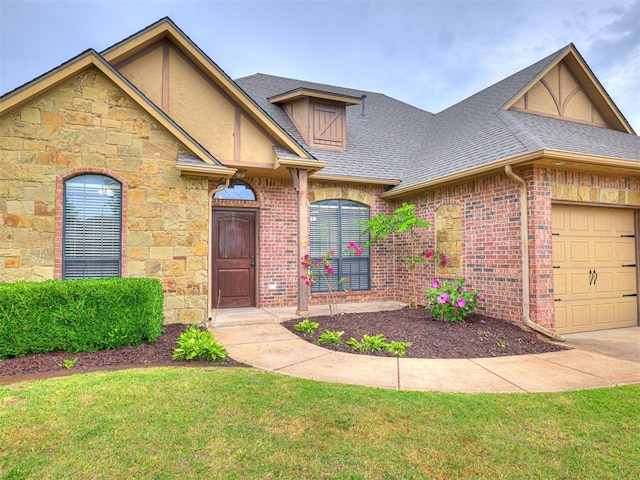 2311 Washita Trl, Edmond, OK 73003 - view of front of home featuring roof with shingles, an attached garage, a front lawn, stone siding, and brick siding