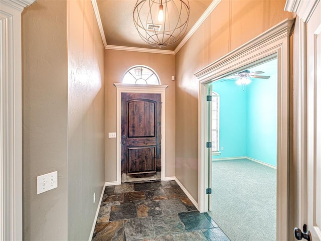 2311 Washita Trl, Edmond, OK 73003 - entrance foyer with crown molding, dark stone finish floors, ceiling fan, and dark colored carpet