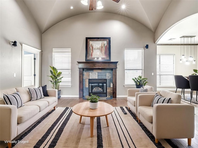 2311 Washita Trl, Edmond, OK 73003 - living area with lofted ceiling, a tile fireplace, wood finished floors, a ceiling fan, and recessed lighting