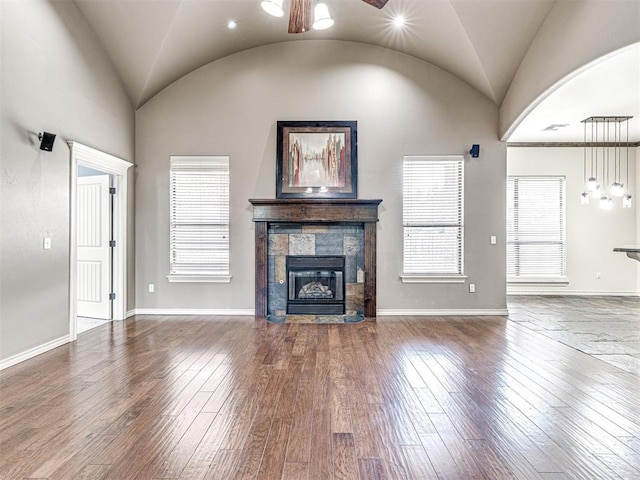 2311 Washita Trl, Edmond, OK 73003 - unfurnished living room with lofted ceiling, a tiled fireplace, hardwood / wood-style floors, and a ceiling fan