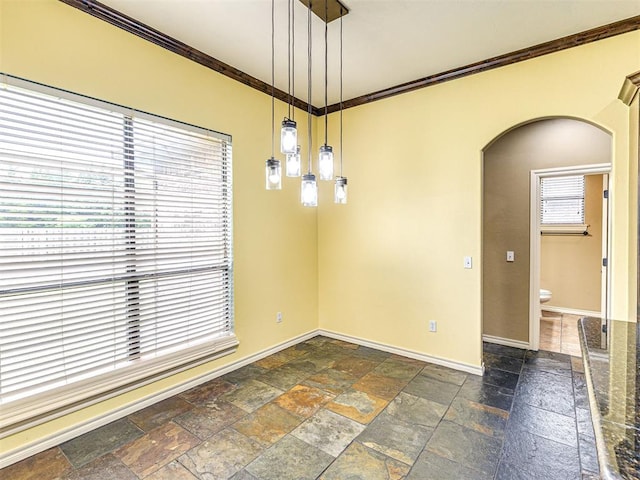 2311 Washita Trl, Edmond, OK 73003 - unfurnished dining area with arched walkways, ornamental molding, and stone tile floors