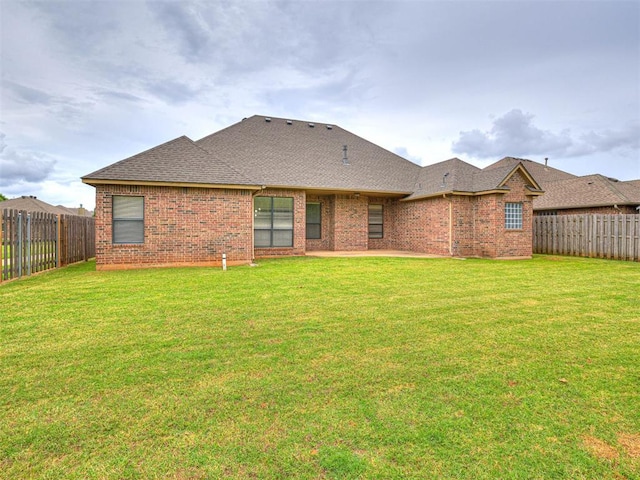 2311 Washita Trl, Edmond, OK 73003 - back of property featuring roof with shingles, a fenced backyard, and brick siding