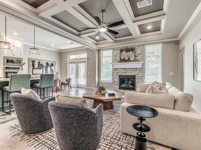 15913 Windrush Pl, Edmond, OK 73013 - living room with crown molding, coffered ceiling, light wood-style flooring, a glass covered fireplace, and ceiling fan