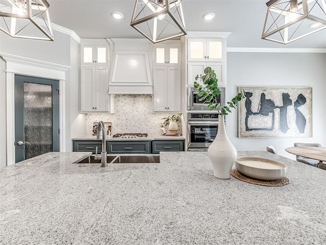 15913 Windrush Pl, Edmond, OK 73013 - kitchen with appliances with stainless steel finishes, premium range hood, a chandelier, crown molding, and light stone countertops