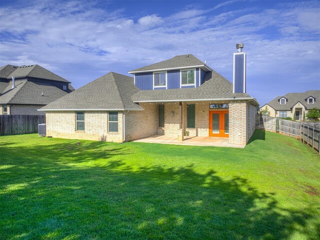 15913 Windrush Pl, Edmond, OK 73013 - back of house featuring a chimney, a fenced backyard, and brick siding