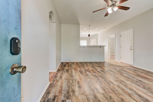 13664 NW Bradbury Ln, Piedmont, OK 73078 - unfurnished living room with wood finished floors, a ceiling fan, and arched walkways