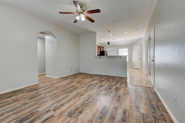 13664 NW Bradbury Ln, Piedmont, OK 73078 - unfurnished living room featuring light wood-type flooring, arched walkways, ceiling fan, and recessed lighting